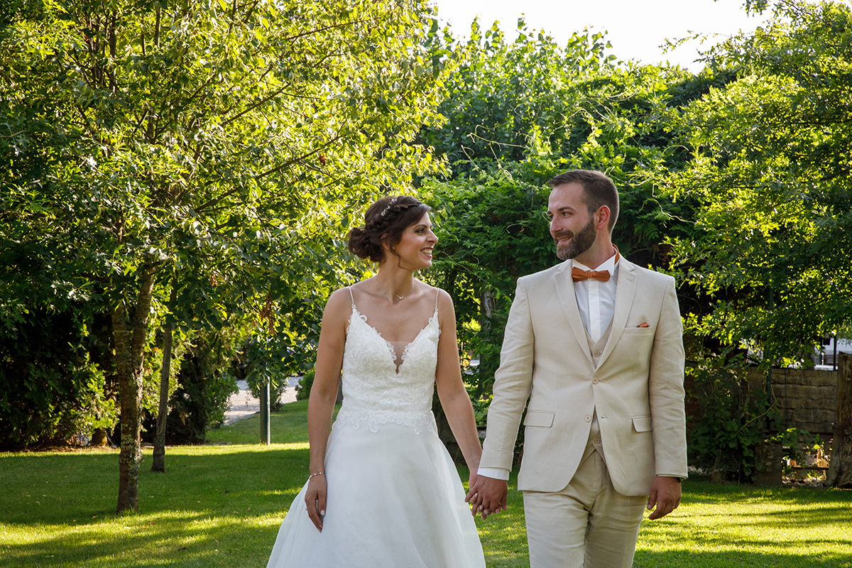 Caminham entre árvores, de mãos dadas, trocando olhares apaixonados. A natureza ao redor parece acompanhar este momento de união e tranquilidade.