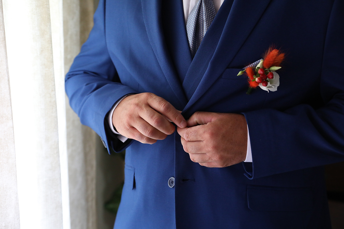 Um pormenor da preparaçao do noivo a apertar o casaco