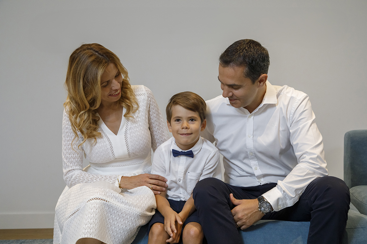 Uma composição perfeita: a mãe com o vestido branco elegante, Ethan ao centro com o seu fato impecável, e o pai com um olhar terno. Os pais sorriem para Ethan, que retribui o olhar para a câmara. Amor em forma de fotografia.