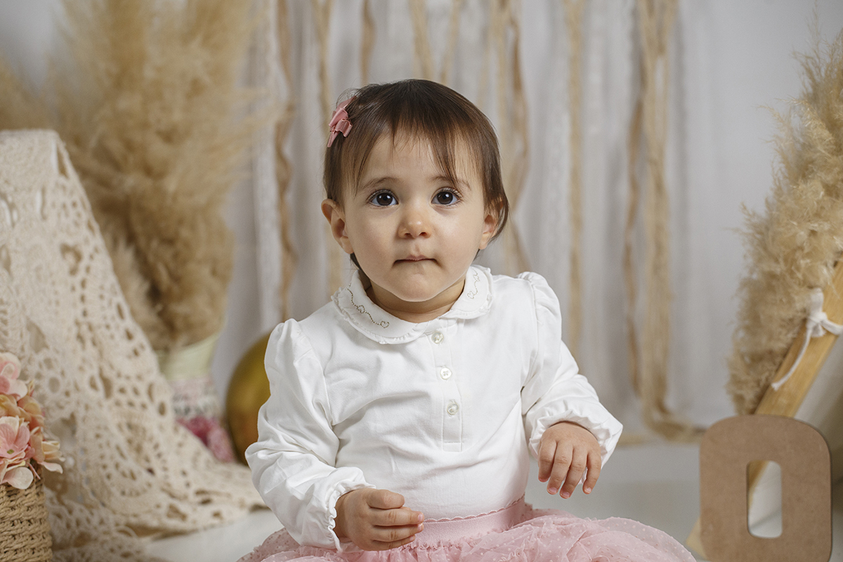 Aqui vemos Matilde da cintura para cima, num plano mais aproximado. Com uma mão pousada na saia rosa e outra mais levantada, encara a câmara com um olhar sério, captado com delicadeza por Ricardo Coimbra Fotografia.