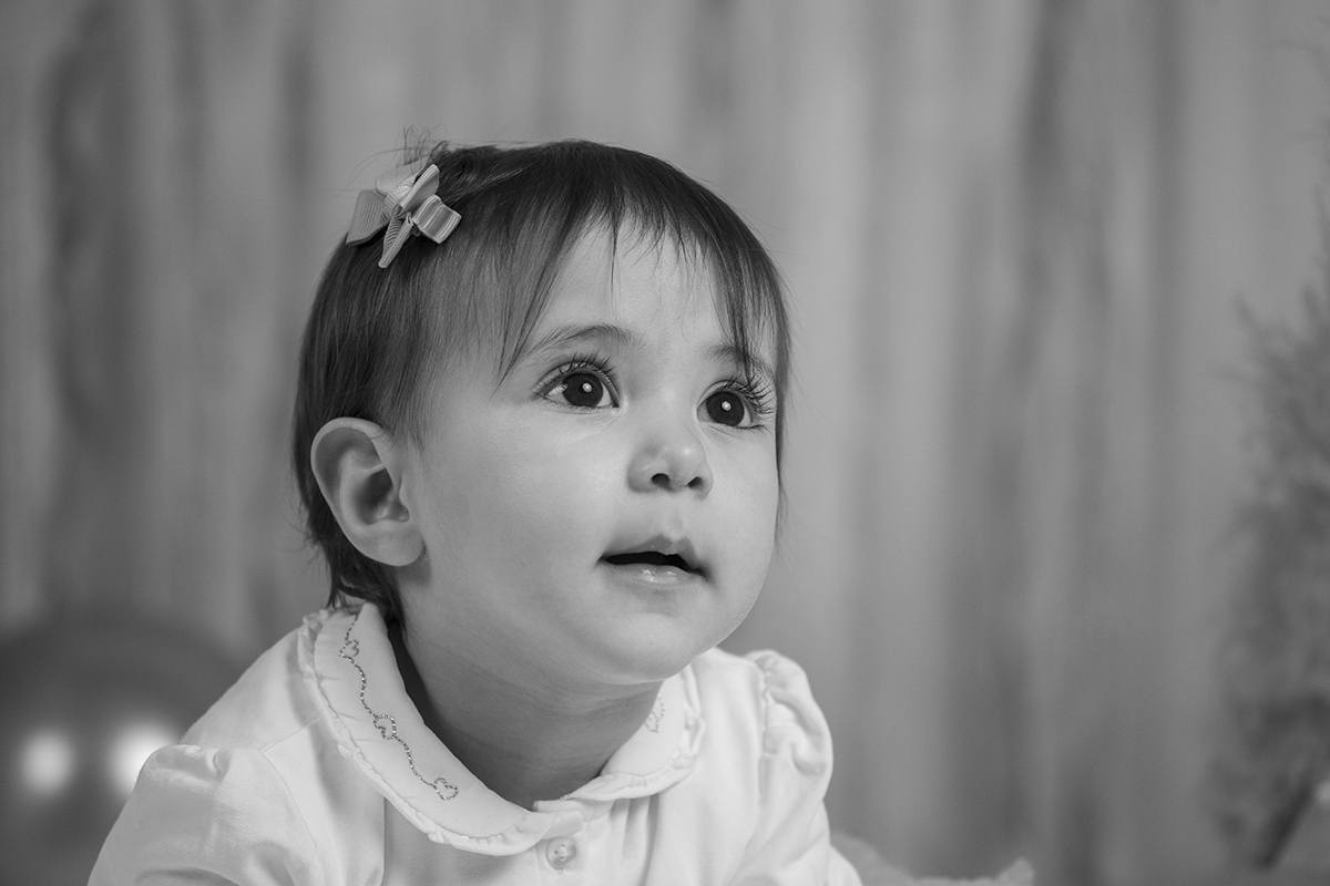 Agora em preto e branco, vemos um plano mais próximo, dos ombros para cima. Matilde olha levemente para a direita com um ar feliz e misterioso. O fundo desfocado valoriza ainda mais a sua expressão.