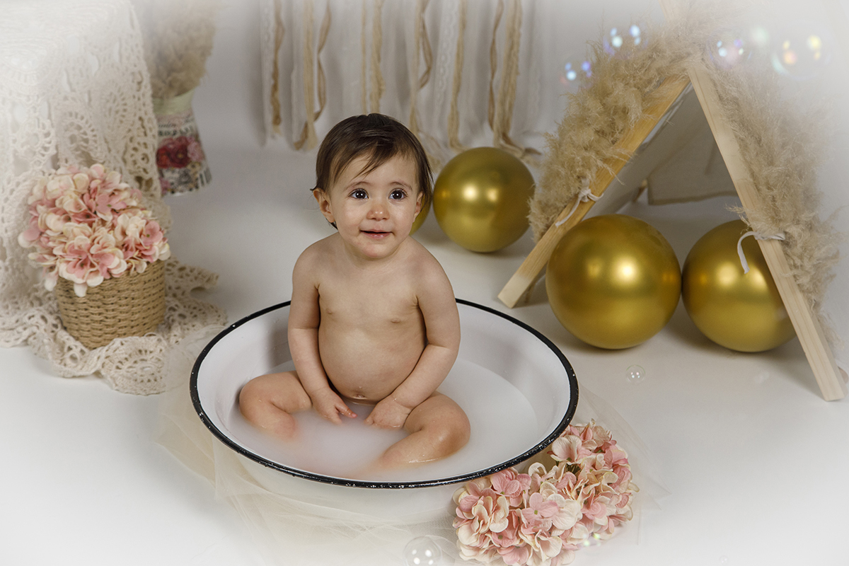 Com um leve sorriso, Matilde está sentada dentro da bacia branca com rebordo preto, a olhar para cima. A vinheta branca e a sua expressão feliz tornam esta imagem um verdadeiro retrato de ternura.
