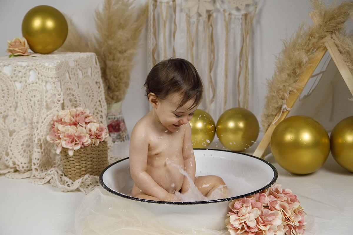 A rir muito, Matilde tem as mãos dentro da bacia e a água a saltar à sua volta. Uma imagem cheia de movimento e alegria, que retrata a inocência e diversão do momento.