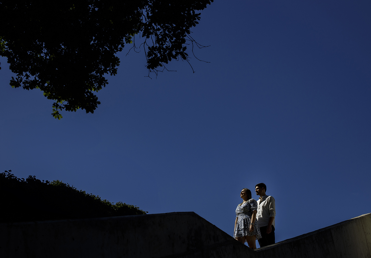 No mesmo cenário, agora mais escuro e com um enquadramento reduzido, Luís e Márcia caminham lado a lado, olhando serenamente para a frente.