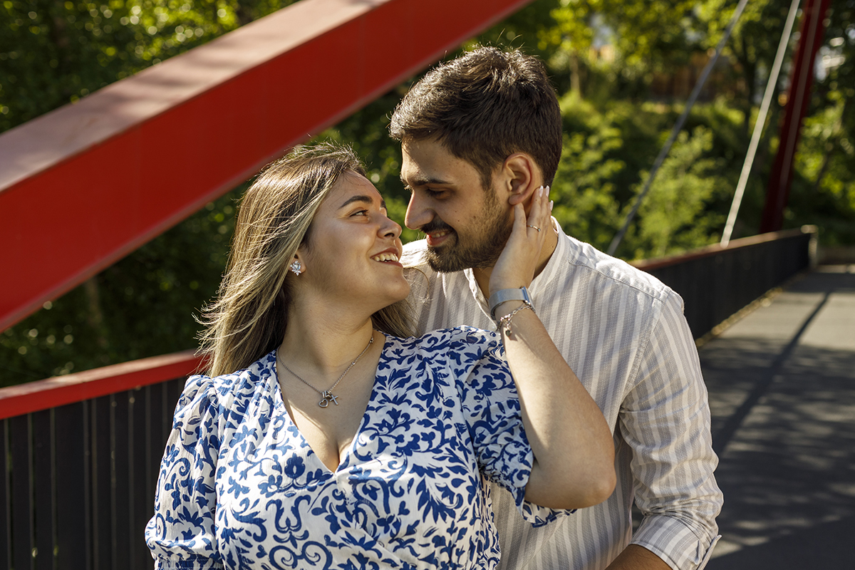 Um plano fechado dos ombros para cima. Márcia, à frente, sorri para Luís, tocando-lhe no pescoço. Ele devolve-lhe o olhar com carinho.