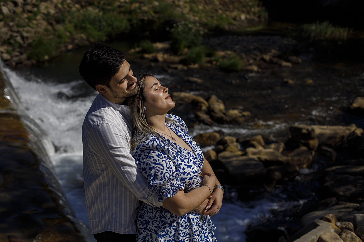 Agora com o fundo nítido, Luís abraça Márcia por trás. Ambos de olhos fechados, voltados para o céu e o sol.