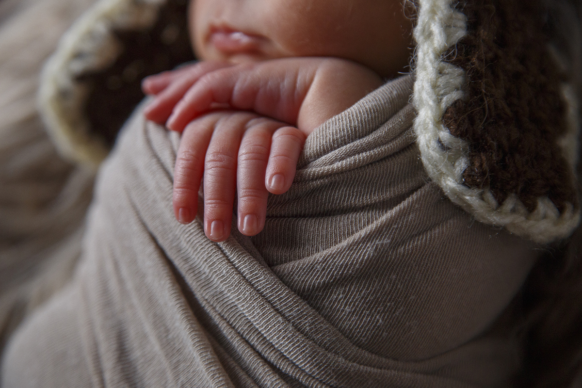 Num plano de detalhe, com o fundo desfocado, focamos a toalha que envolve Gabriel, as suas pequenas mãos e parte do seu rosto, incluindo os lábios.