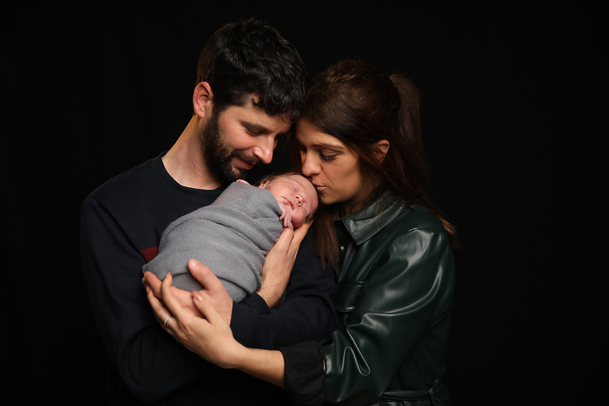 Na mesma posição, agora com o pai a sorrir para Lourenço e a mãe a beijá-lo na testa. Um retrato terno e envolvente.