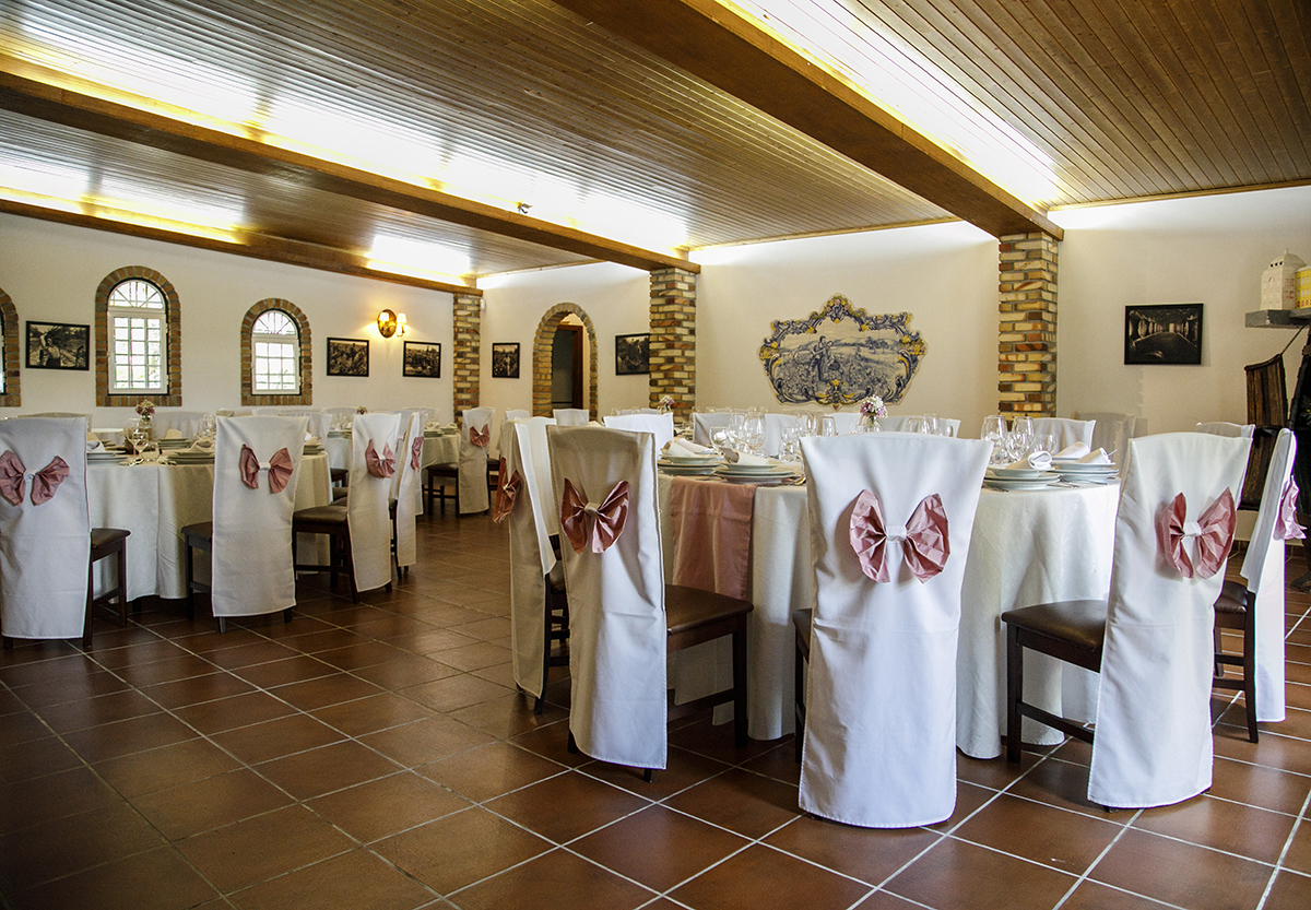 Depois do Batismo, vemos a sala decorada com cadeiras de madeira cobertas por lençóis brancos e laços rosa. Um espaço harmonioso e requintado. quinta da boiça
