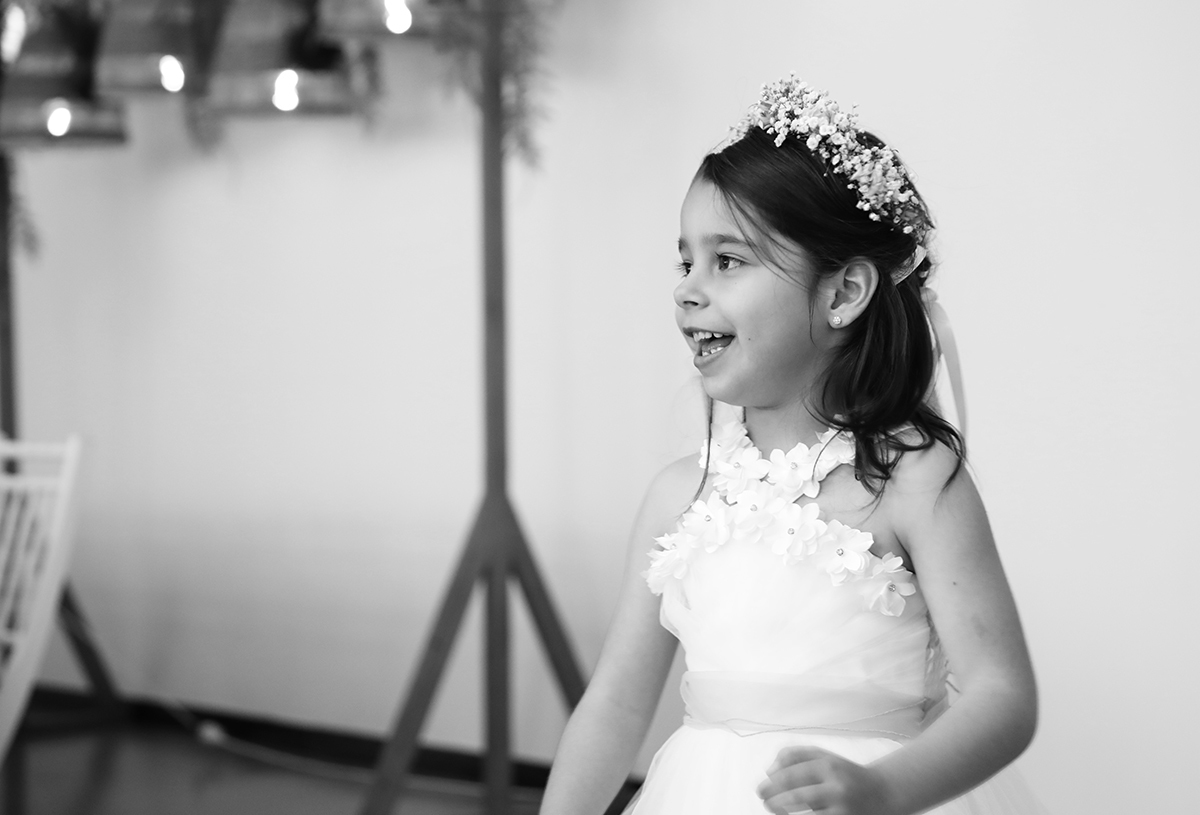 À direita da imagem, Joana aparece da cintura para cima, de lado, a olhar para algo fora da câmara com um sorriso sincero e curioso.