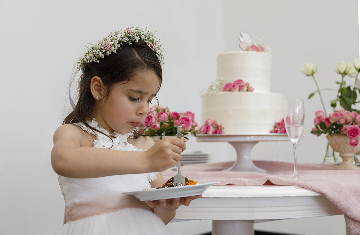 Sentada à frente do bolo, Joana está concentrada a saborear o momento. Atrás, vê-se a mesa decorada com muito cuidado, num cenário de festa e amor.