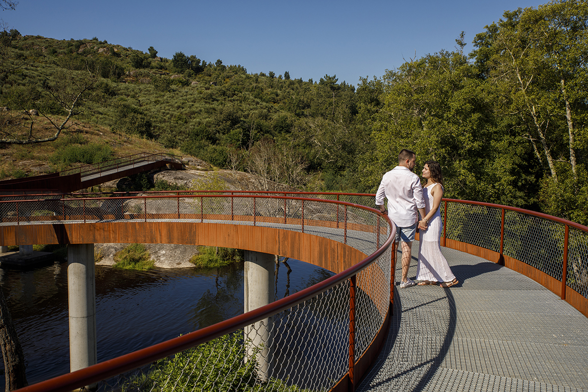Na curva suave da ponte, o rio corre por baixo e os olhares cruzam-se entre sorrisos e silêncio. Sessao solteiros