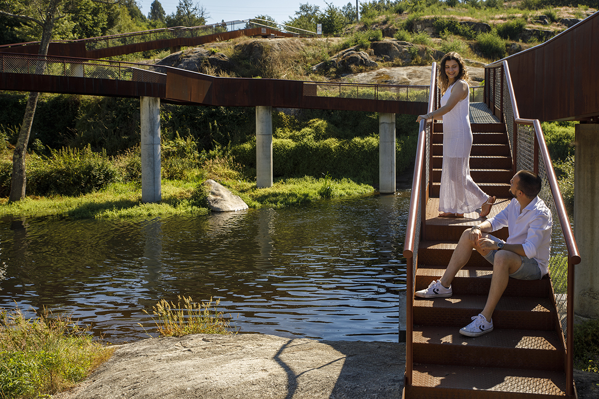 Sandra em pé, Rafael sentado. Trocam olhares enquanto a ponte os envolve.