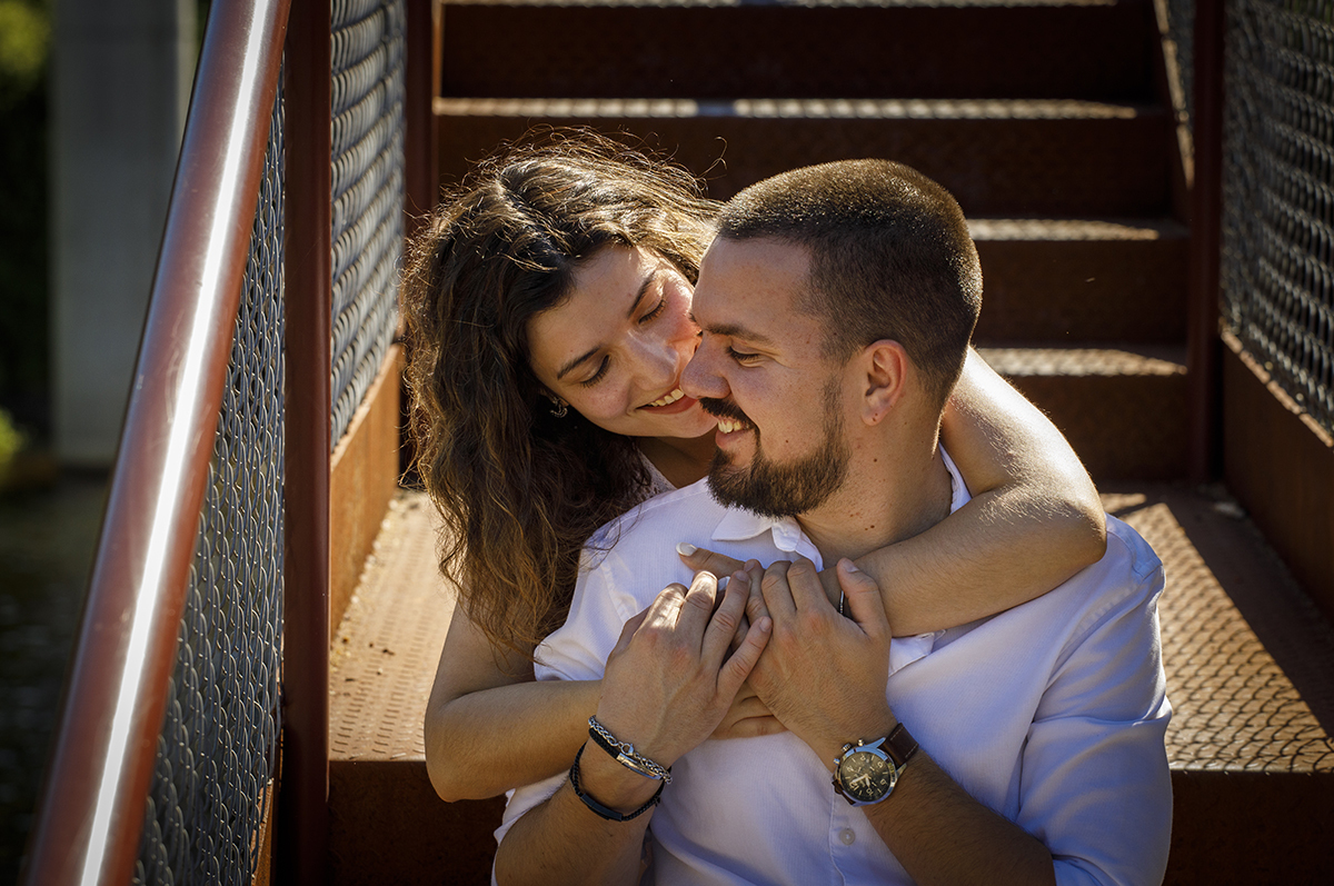 Sandra abraça Rafael por trás. As mãos dele tocam-lhe ao peito. Um olhar apaixonado entre os dois.