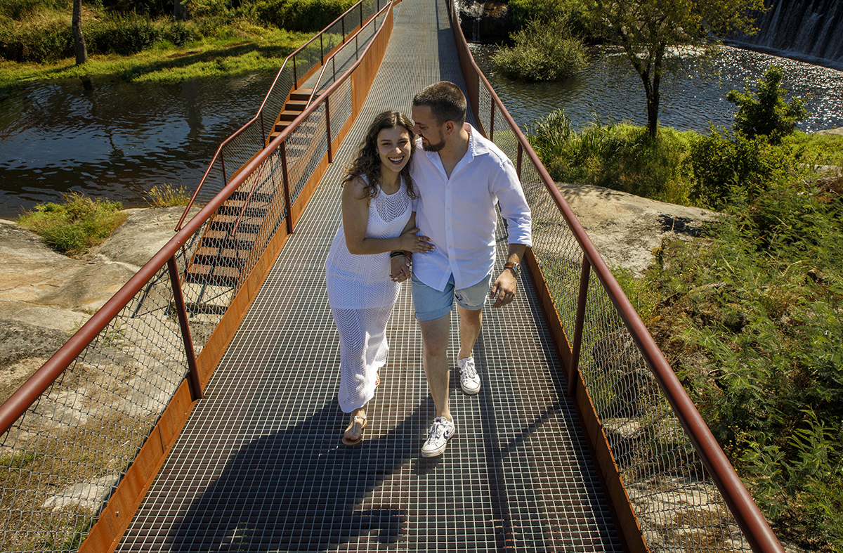No mesmo cenário, Sandra sorri divertida enquanto apoia a mão na barriga de Rafael.
