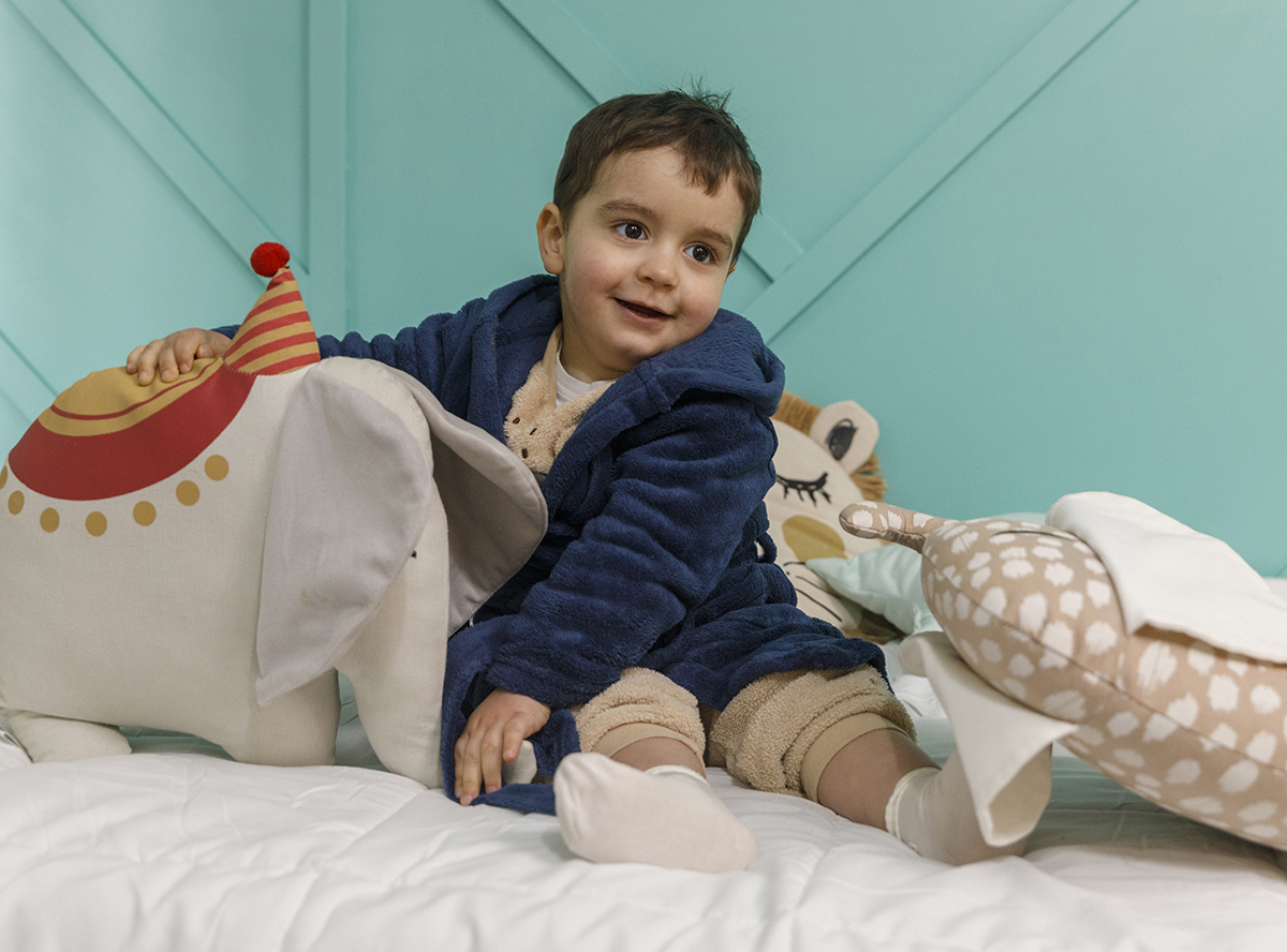 Salvador, de pijama e robe, repousa na sua cama rodeado dos seus bonecos preferidos. Um momento de ternura em casa, captado com sensibilidade por Ricardo Coimbra Fotografia.