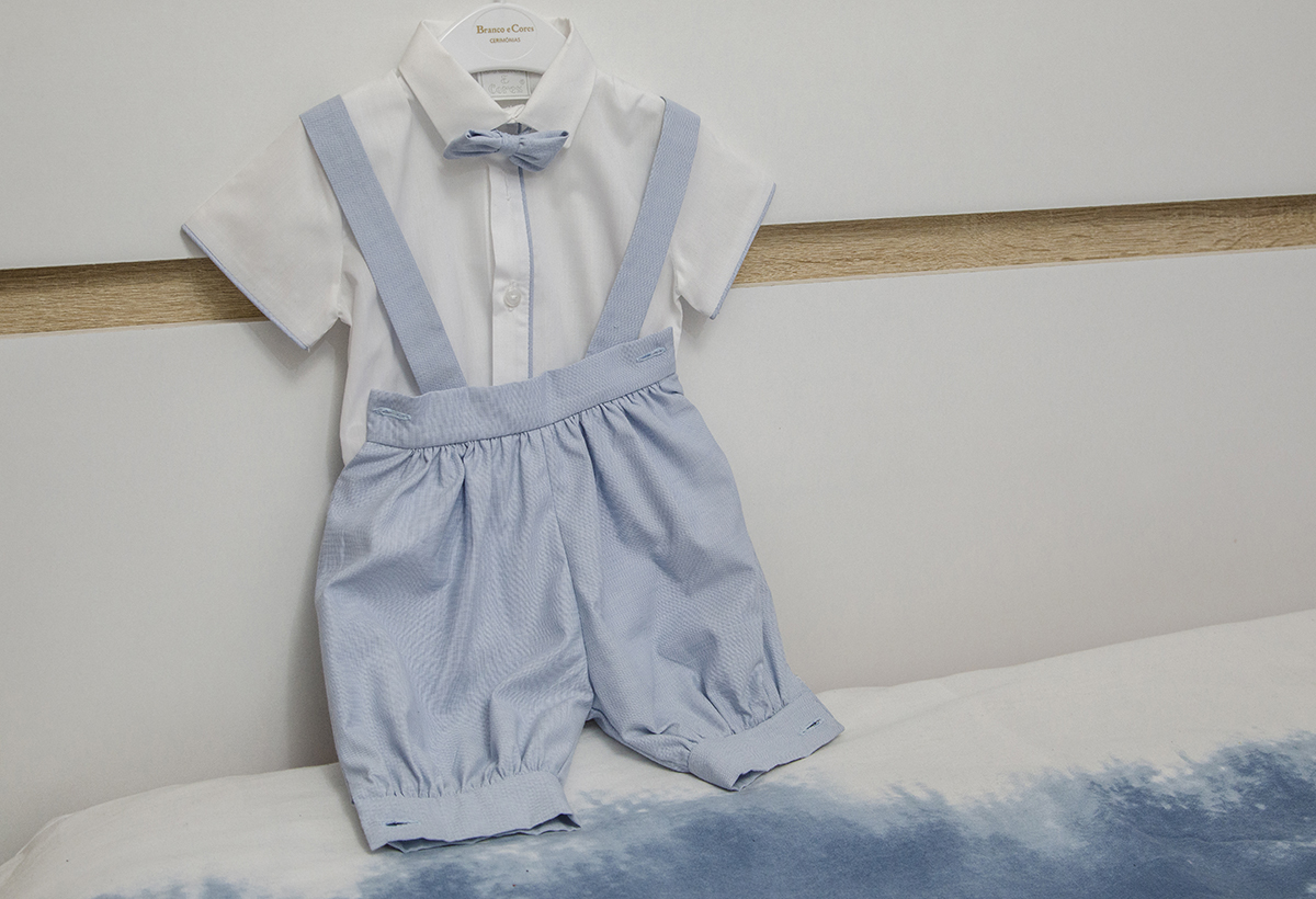 O fato de batizado do Mário, em tons de branco e azul bebé, repousa sobre a cabeceira da cama, aguardando o grande momento.