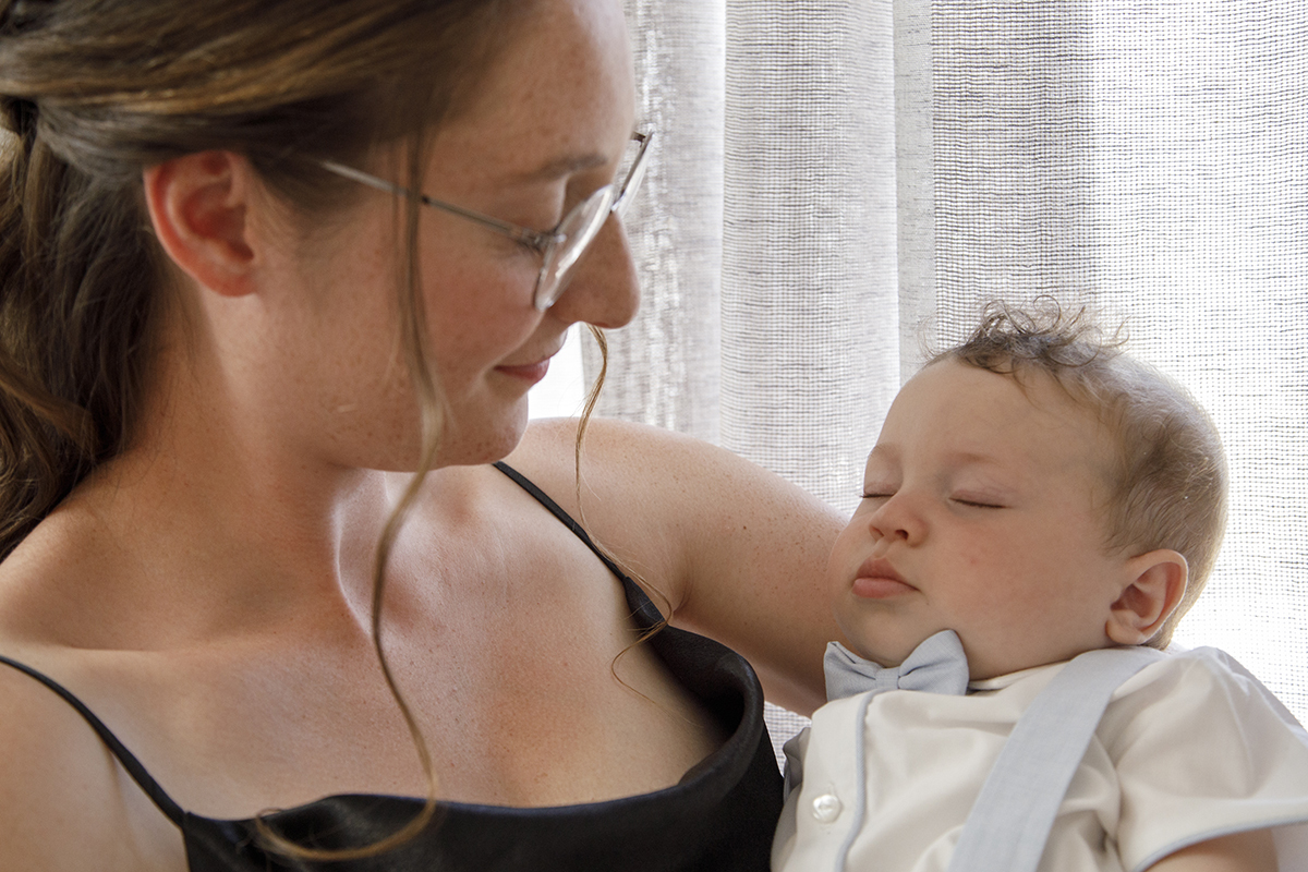 Também em plano próximo, a mãe embala o seu filho ao colo enquanto ele dorme, num instante terno e silencioso.
