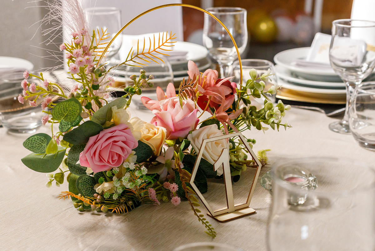 Ao centro da mesa, um cestinho de flores e um número de madeira marcam o lugar, com delicadeza e encanto.