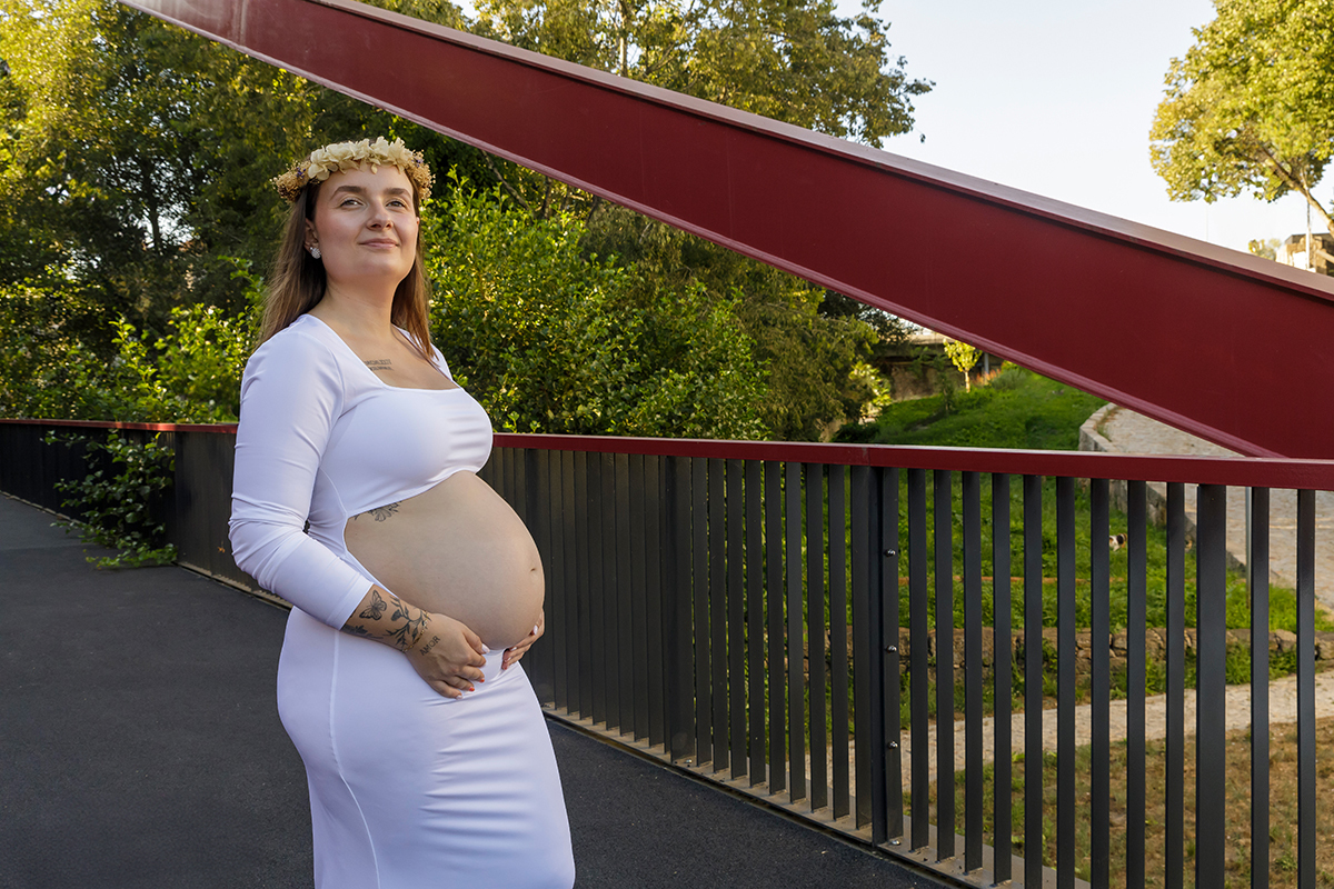 Em uma ponte, a Futura Mãe feliz a pensar no futuro.