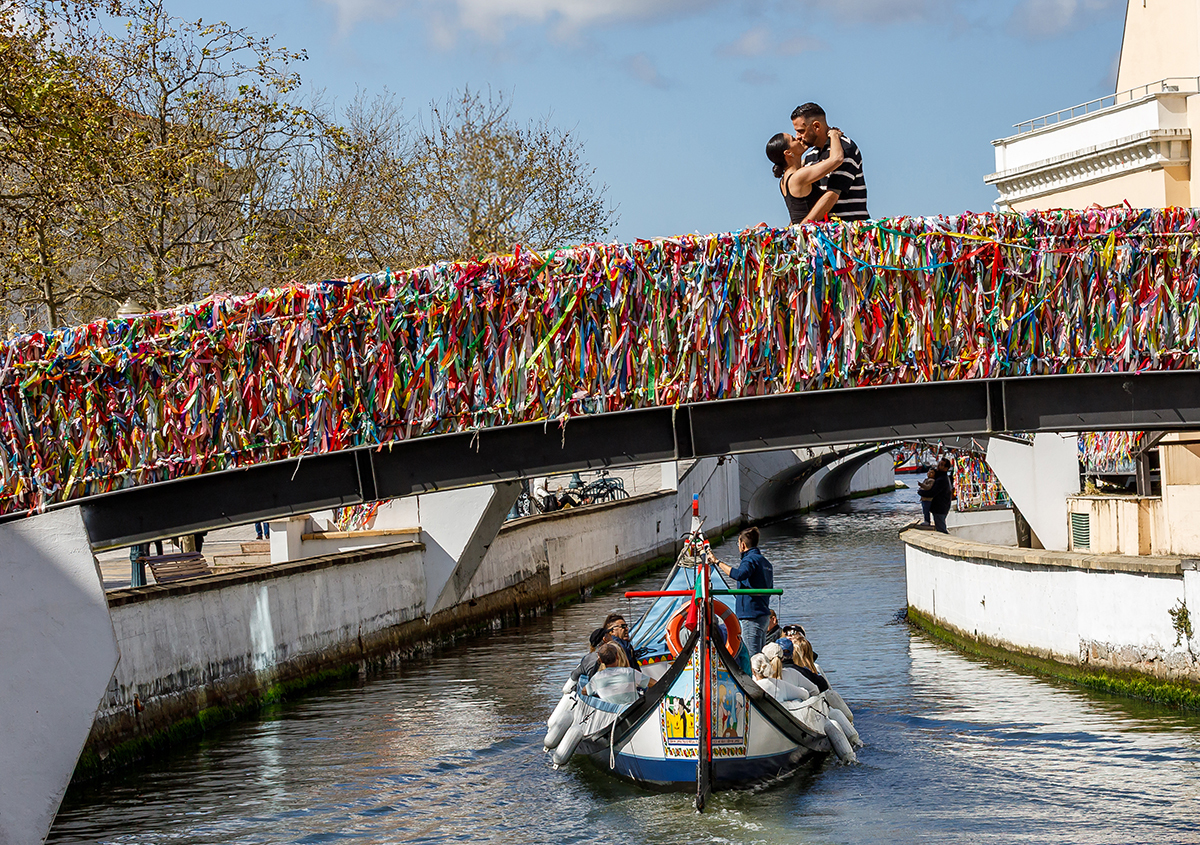 Vanessa e Philippe posam em frente a um moliceiro tradicional na Veneza Portuguesa.