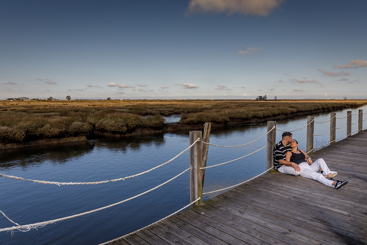Vanessa e Philippe sentados no rebordo do passadiço com a imensidão da ria como cenário.