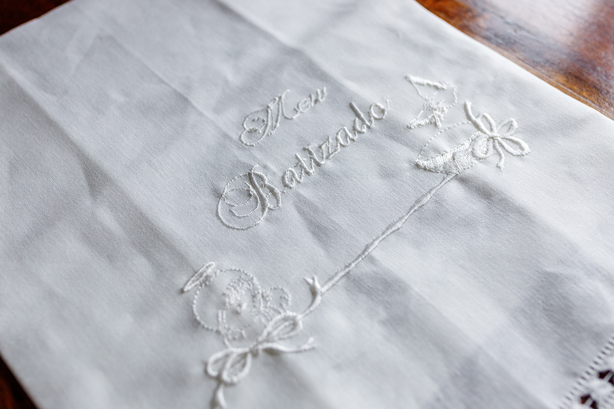 A toalha de batismo bordada e a concha de prata sobre a cama, um detalhe fotocoimbra.