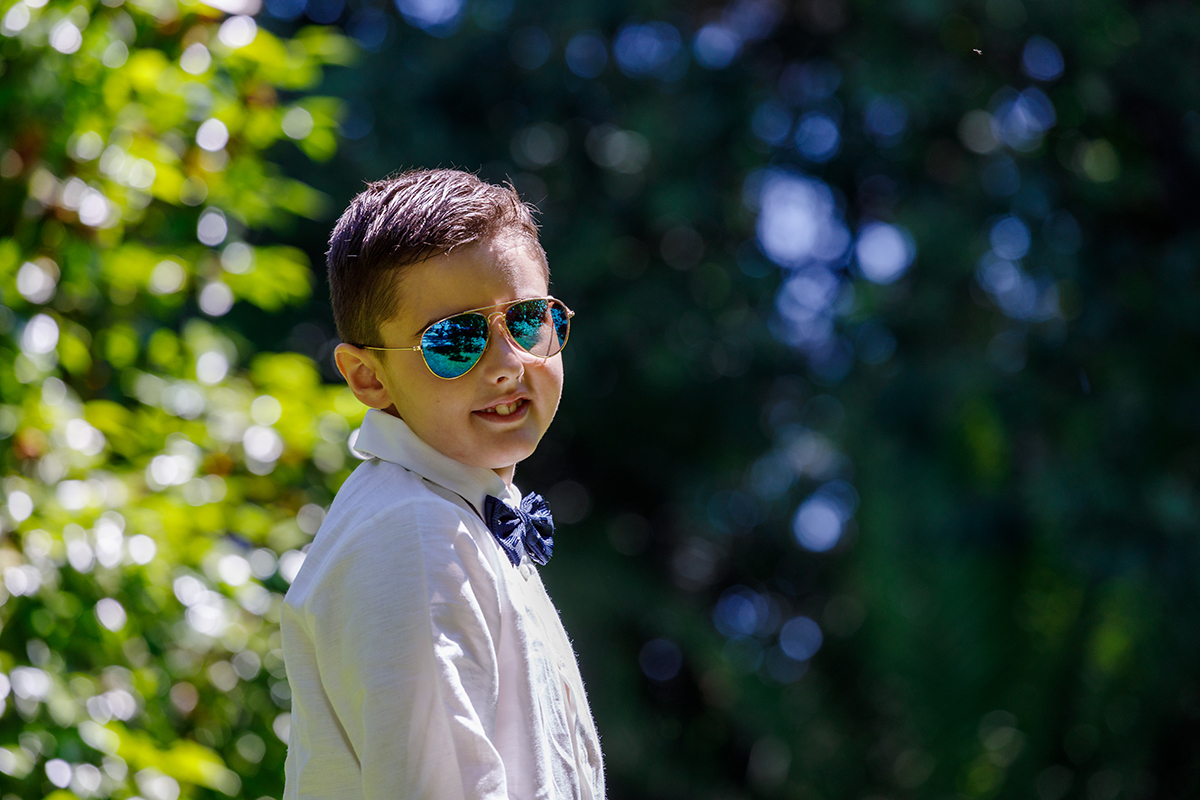 O Salvador sentado na relva fofa da Quinta da Boiça com o casarão de fundo, fotografia de fotografo-casamento-tondela-viseu.