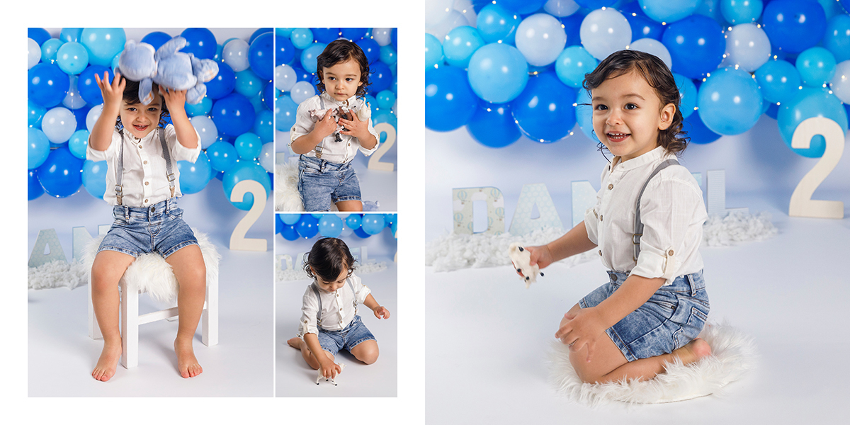 O menino Daniel sentado e divertido a brincar com um dos baloes azuis na sua sessao dois anos, uma memória criada por fotografos tondela