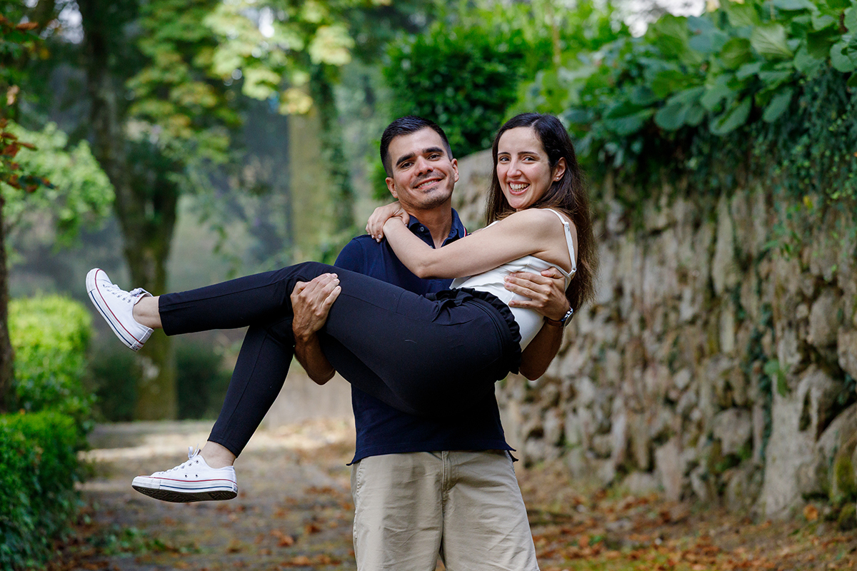 Casal a sorrir entre a natureza no Parque do Caramulo, sessão leve e natural por fotógrafos de casamento Tondela e Viseu.