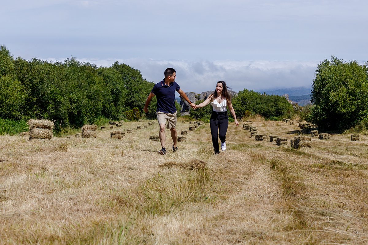 Casal em cenário rústico com fardos de palha e paisagem natural no Caramulo, fotografia por Fotocoimbra.