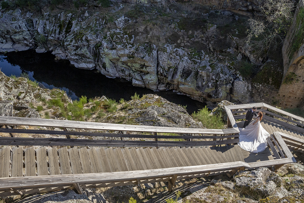 Do alto, o drone capta uma visão mágica: sobre uma escada dos passadiços, Daniela e Jorge encaram-se com ternura. Ao lado, entre as rochas, o Rio Paiva serpenteia, como se acompanhasse o compasso do seu amor.
