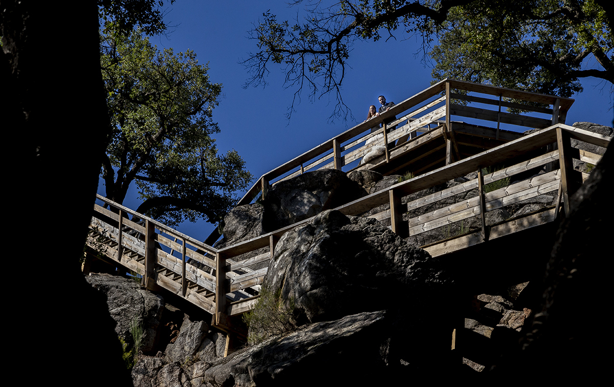 Do alto do monte, os passadiços serpenteiam e lá no topo estão eles. Com as mãos sobre o corrimão e os olhos a sorrir para baixo, partilham um momento de plenitude com o mundo.