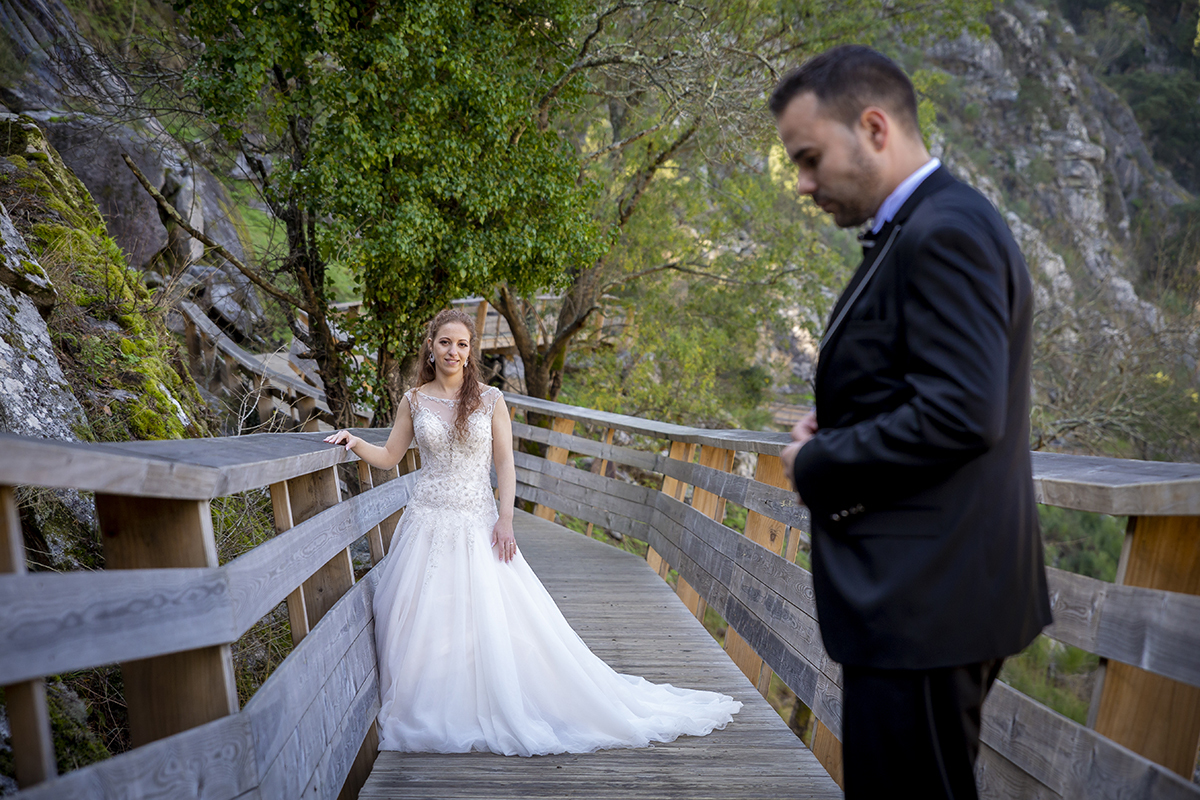 Numa composição harmoniosa, Daniela sorri para cima, mão no corrimão, enquanto Jorge, desfocado e mais acima, olha para baixo. Um olhar cruzado, mesmo sem se verem diretamente.