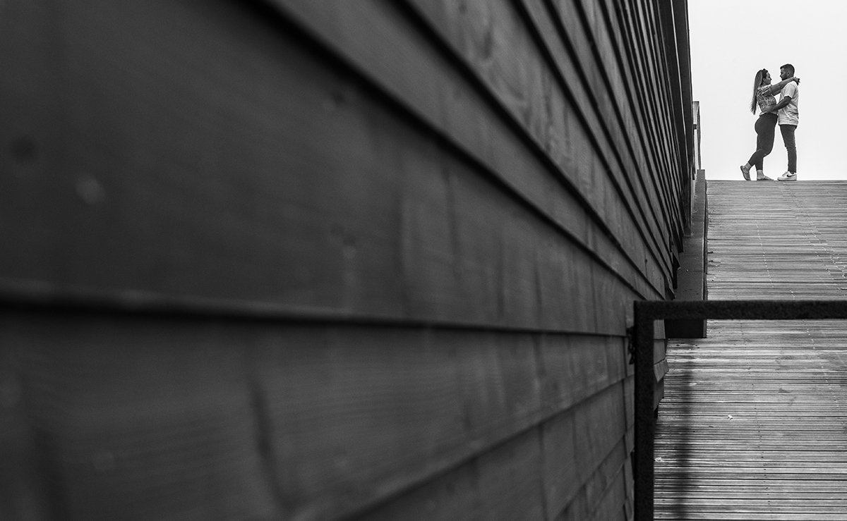 Com a câmara encostada a uma parede de madeira no lado esquerdo da imagem, vemos ao longe os dois no mesmo gesto terno da imagem anterior, como se o tempo tivesse parado para contemplar aquele instante de amor.