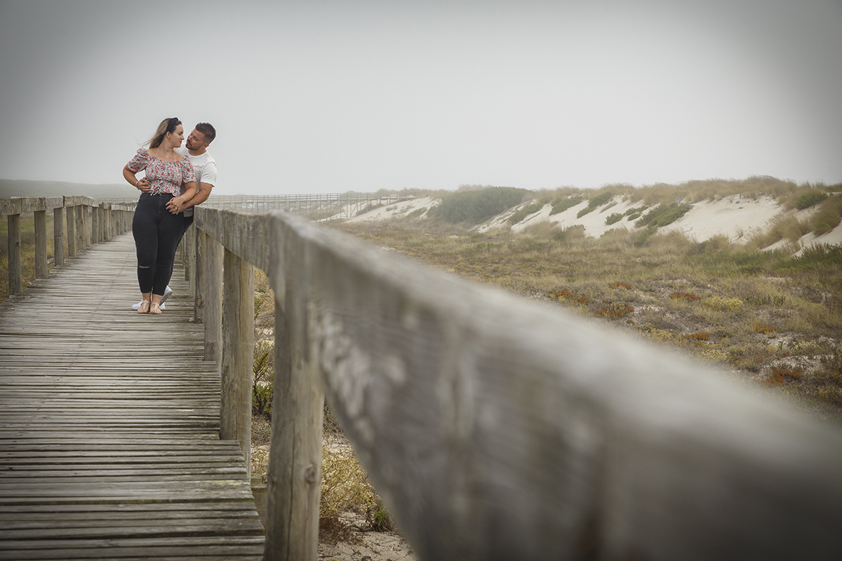 Nos passadiços de madeira, Ricardo caminha atrás de Marta que segue à frente, e quando ela olha para trás, os olhares encontram-se num momento sério mas cheio de intensidade, com as mãos dele a apertarem-lhe a cintura como um porto seguro.