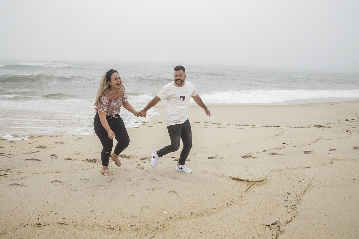 Aqui ainda no mesmo cenário vemos os dois um pouco mais à frente, ainda a correr mas agora com a água já a recuar, e os dois a rirem-se muito, libertos e felizes como crianças na praia.
