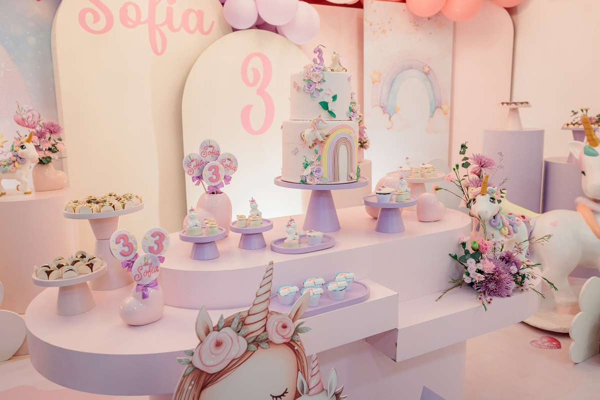 Menina sorrindo soprando as velas no bolo de aniversário de 3 anos em Caxias do Sul.