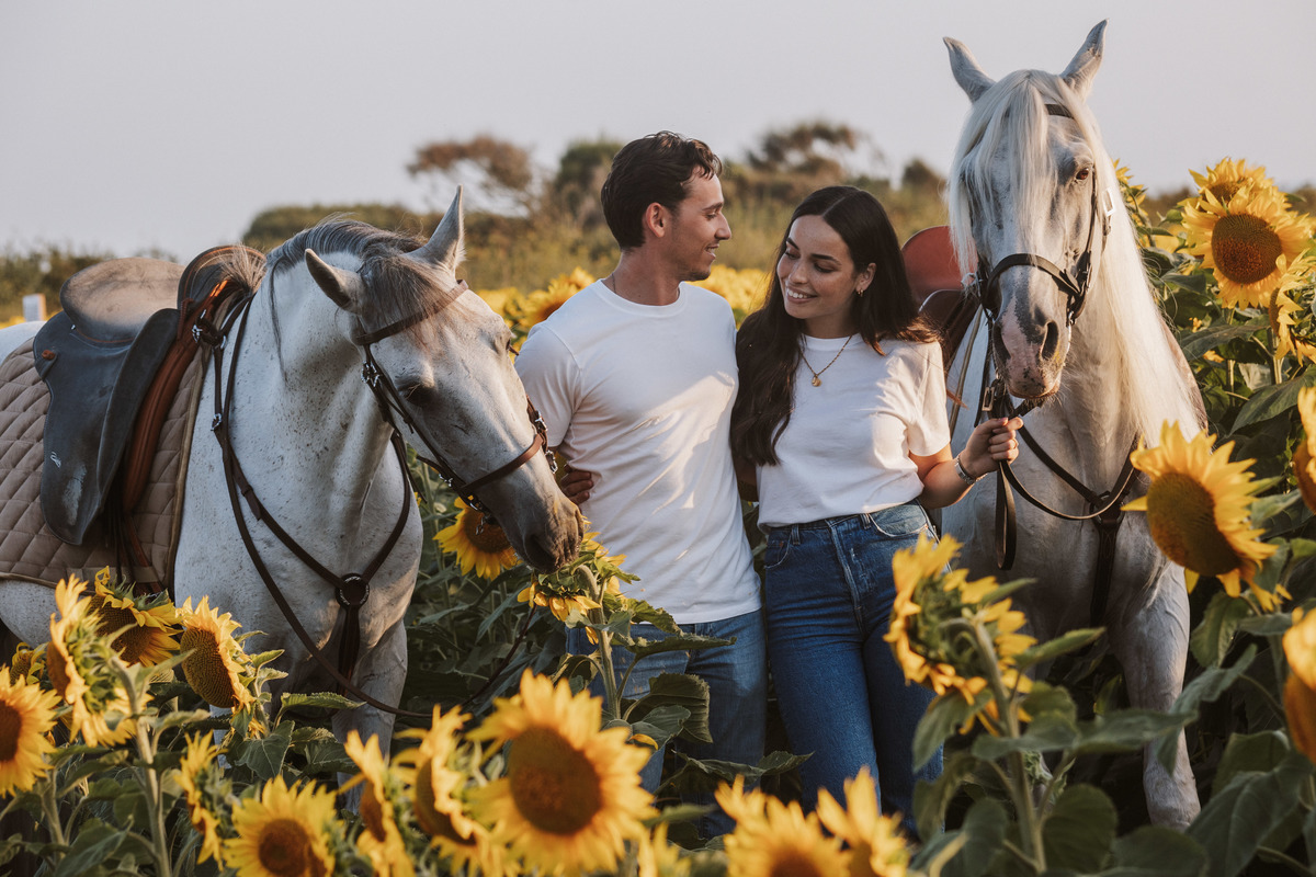 Retrato de casal em sessão de solteiros no campo, fotografia natural com paisagem agrícola.