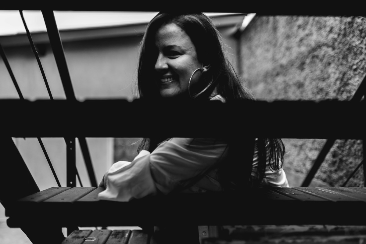 foto em preto e branco de mulher apoiada na escada.