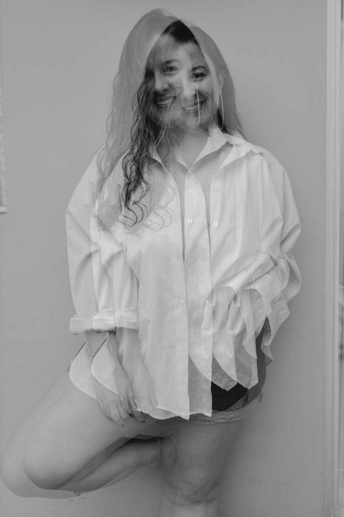 foto em preto e branco  de mulher com camisa encostada na parede. foto com com sobreposição de a mesma imagem.