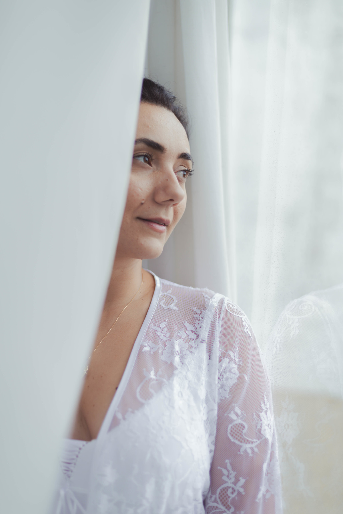 foto de mulher de hobby branco olhando através do vidro da sacada