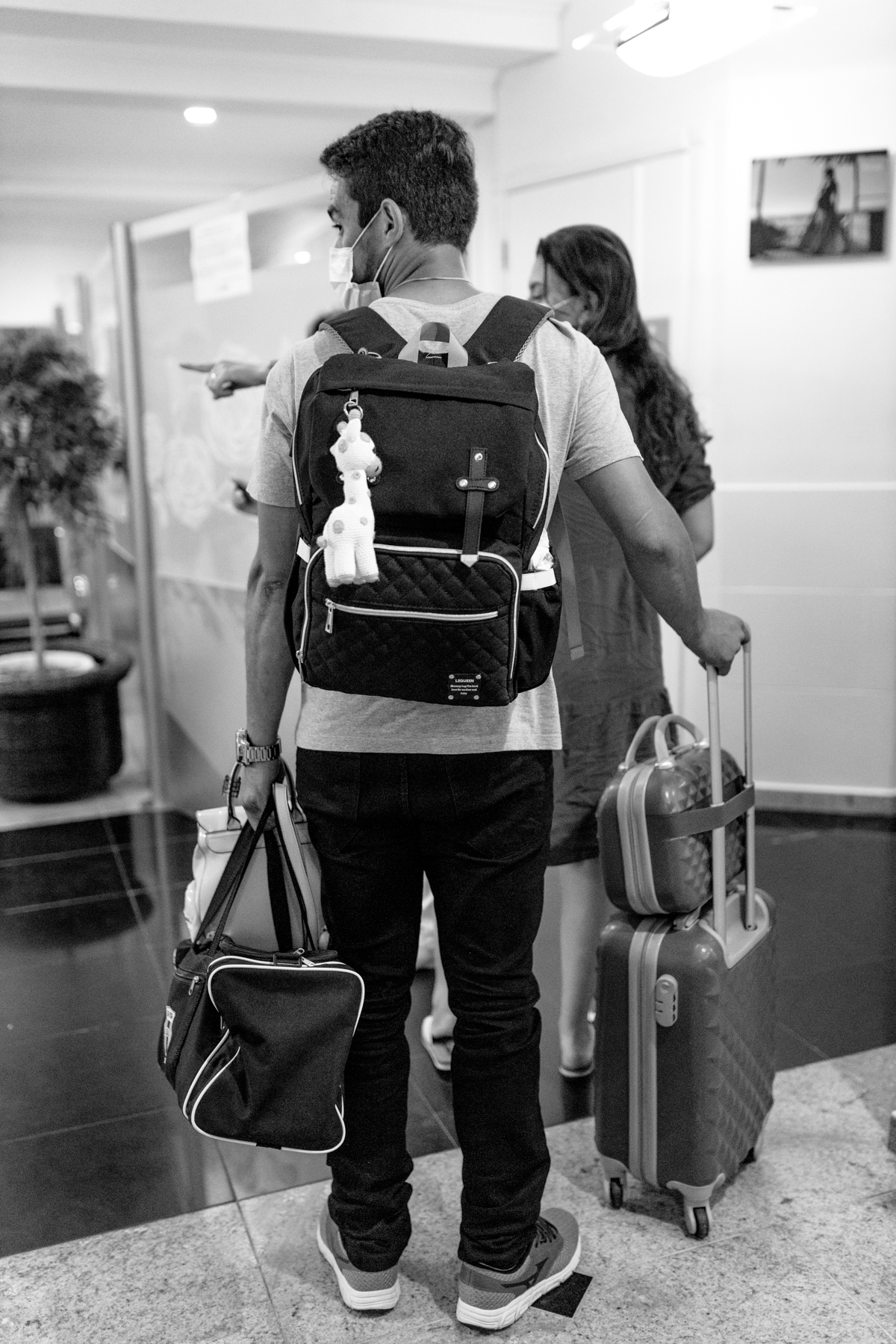 pais chegando na maternidade com as malas para o parto. foto em preto e branco