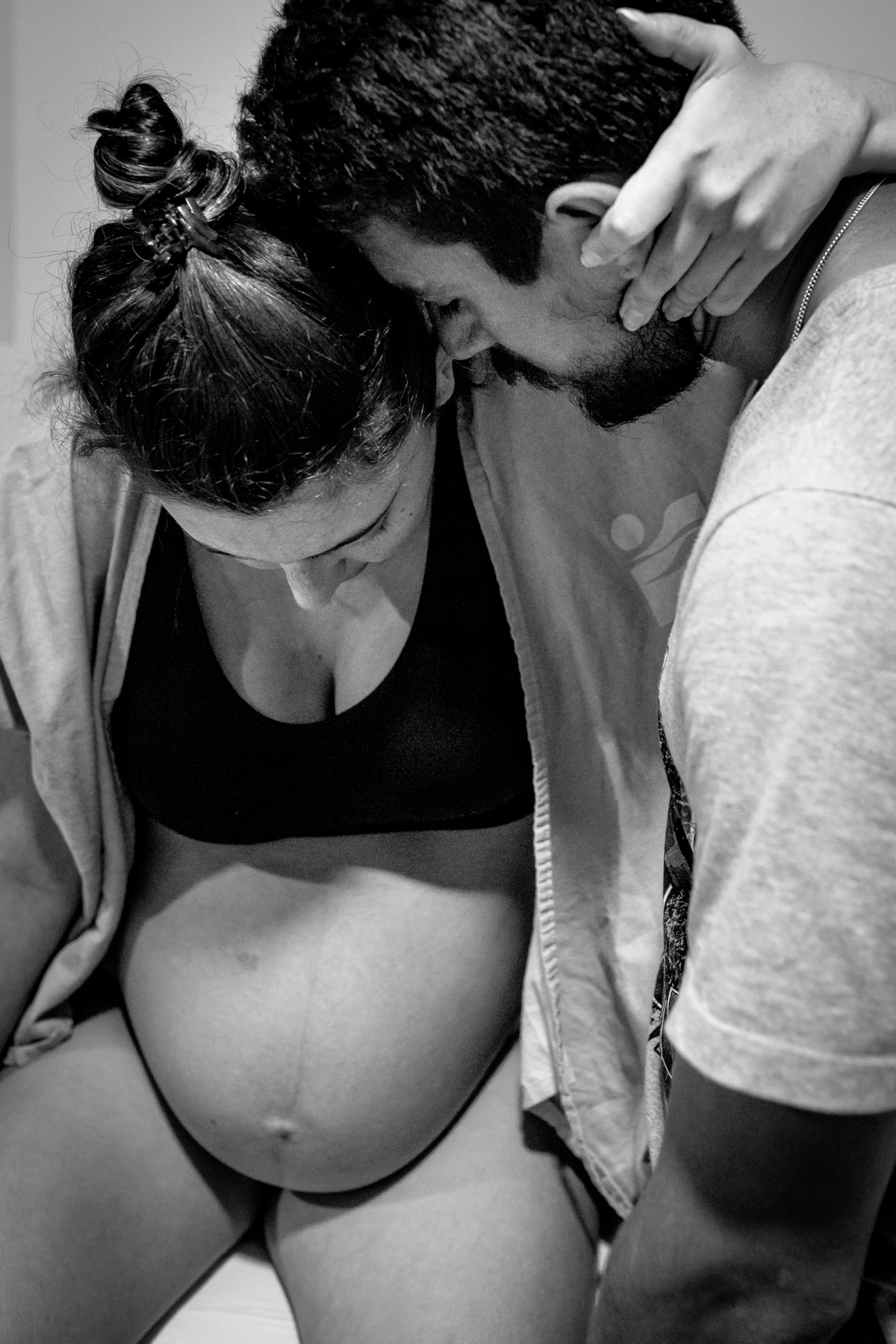 homem de olhos fechados abraçado na mulher grávida de olhos fechados. foto em preto e branco