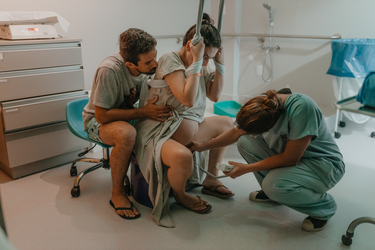 médica escutando os batimentos cardíacos de mulher em trabalho de parto na maternidade em Florianópolis