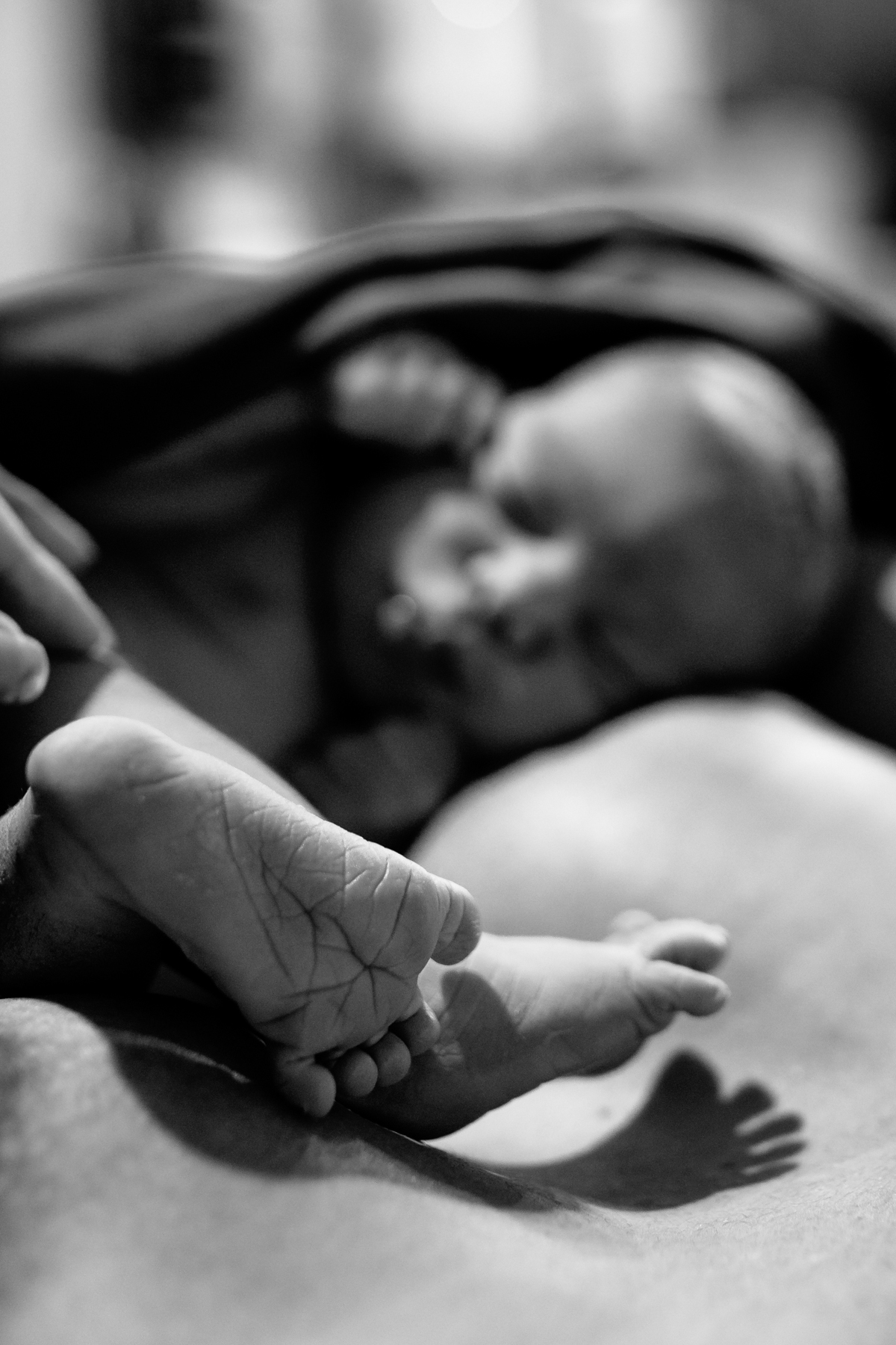 foto de bebê recém nascido com foco no pezinho. em preto e branco