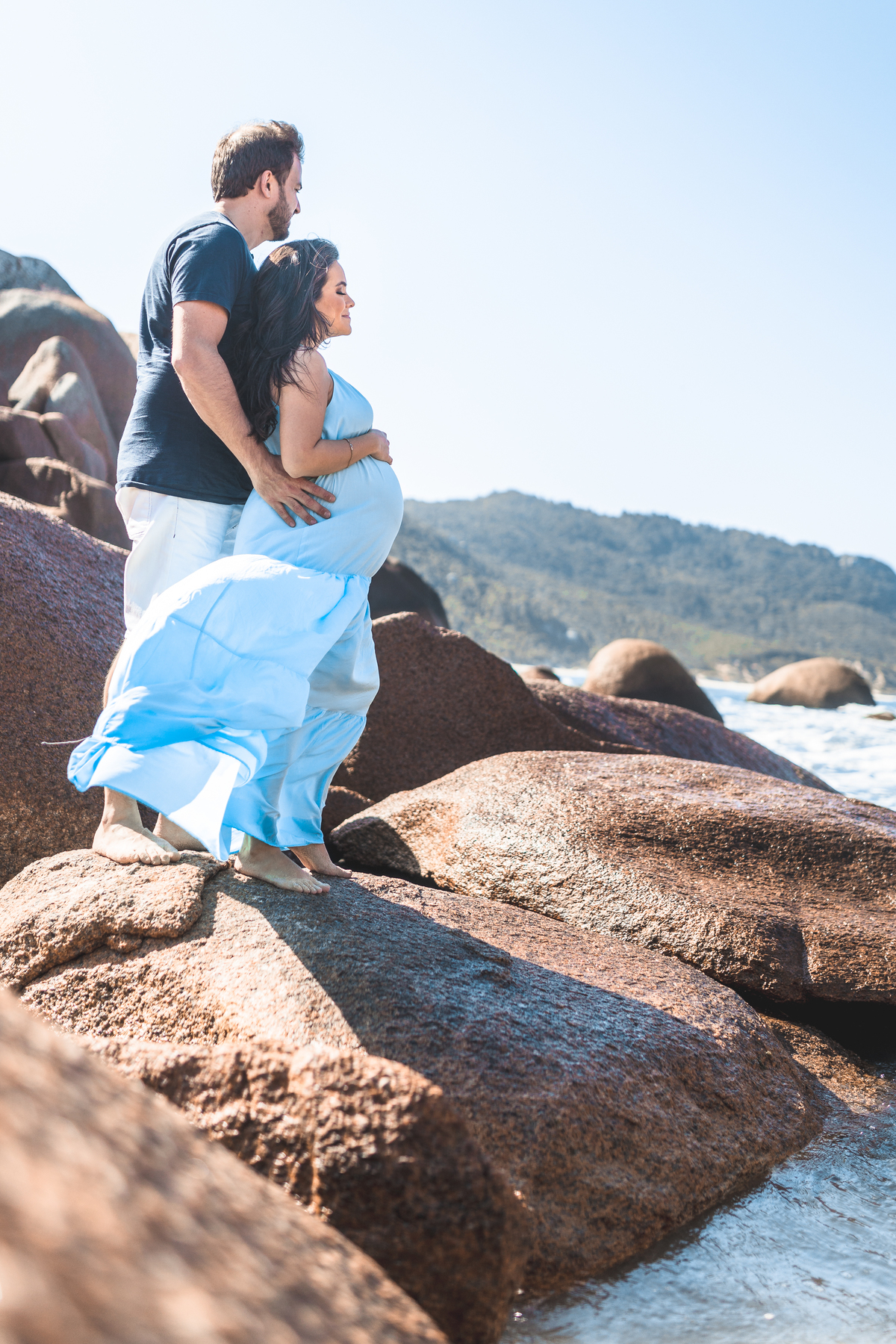 casal apaixonado, esposa gestante, abraçados na praia de Florianópolis