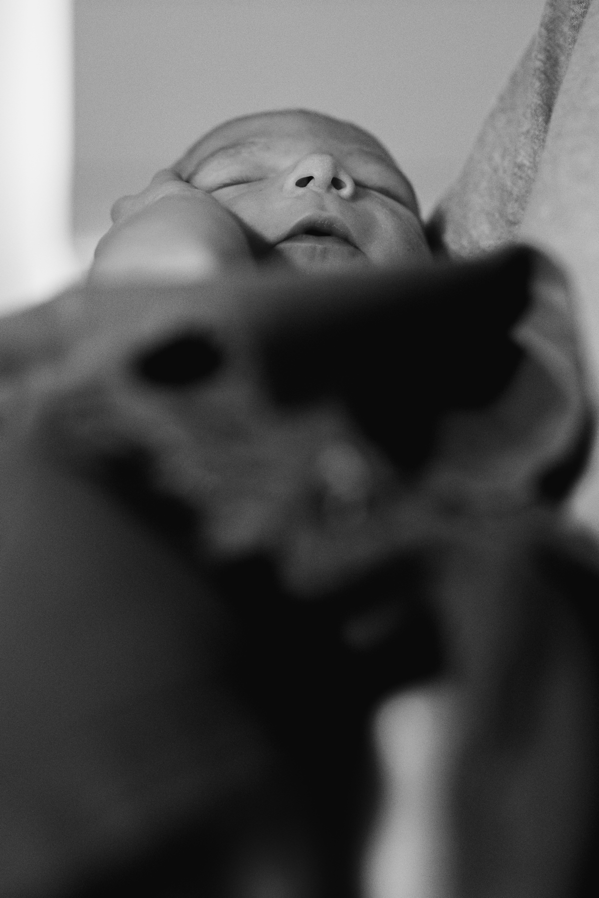 foto em preto e branco de bebê enrolado em coberta no colo do pai