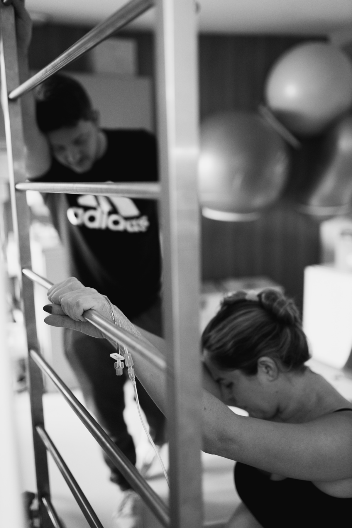 gestante em trabalho de parto no espaldar da maternidade com o marido de fundo