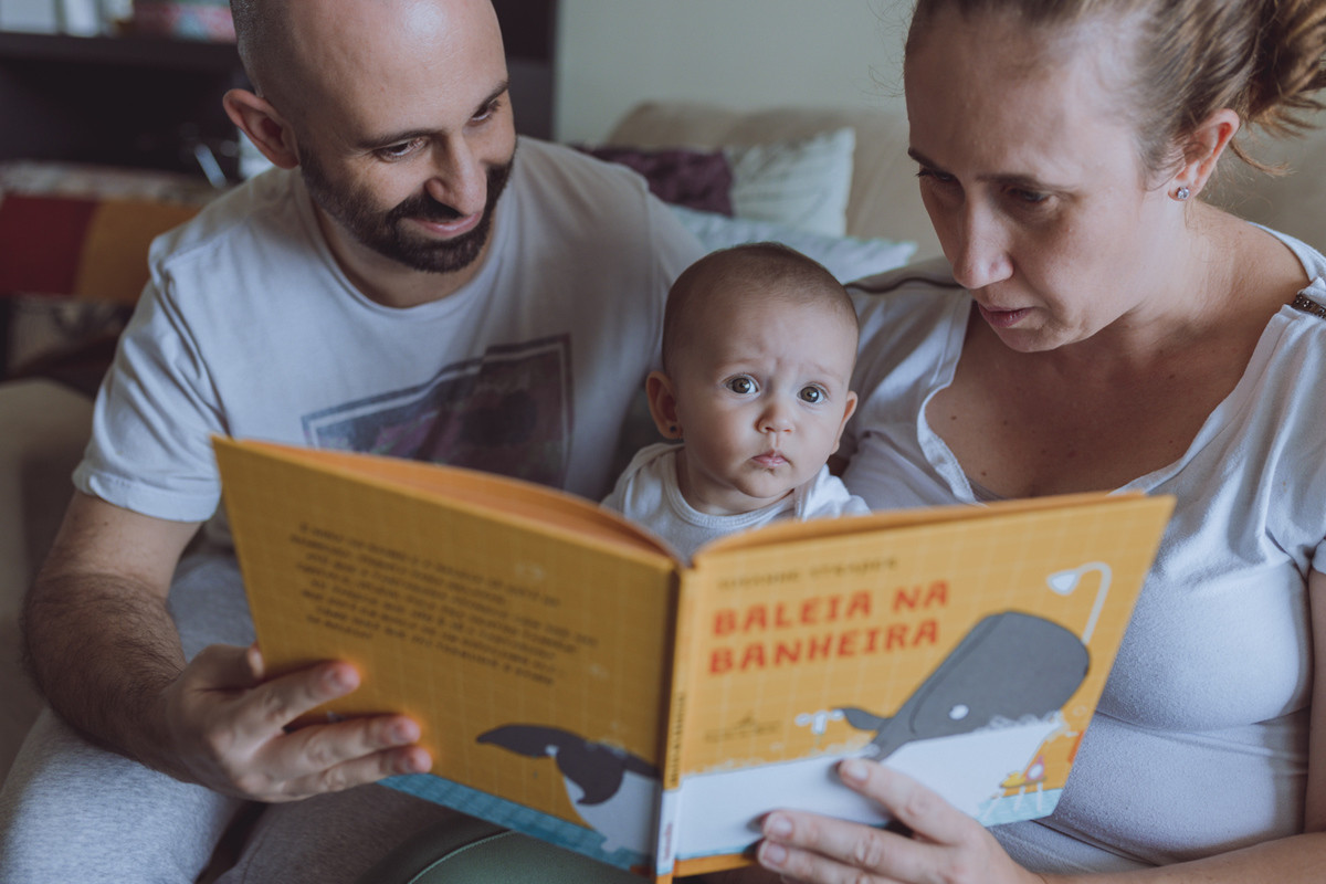 bebê distraído enquanto pais leem livro